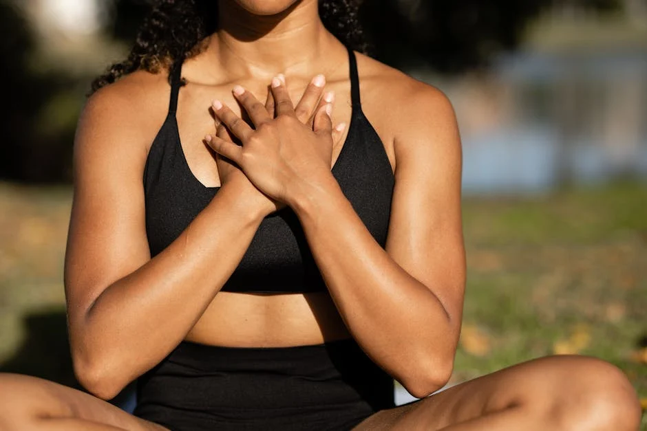 Femme ronde assise par terre les jambes en tailleur dans un parc
