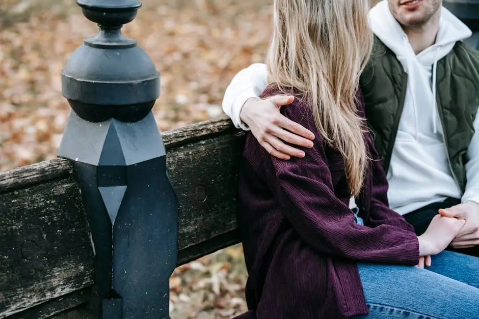 Un jeune couple assis sur un banc dans un parc lors de leur premier date