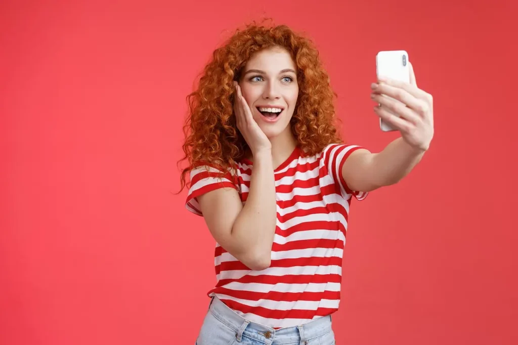 Une femme heureuse se prenant en selfie pour envoyer la photo à son chéri